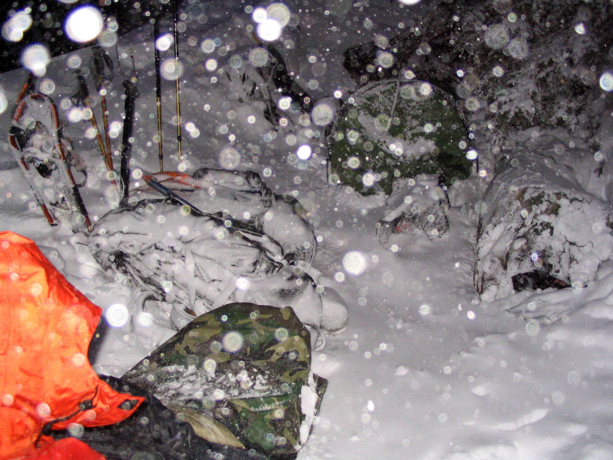 After searching for six hours, the 304th Rescue Squadron search team bivouacked in the snow to rest and eat to regain their strength before continuing the search for the missing climbers.  (U.S. Air Force Photo/Capt. Mark Ross)