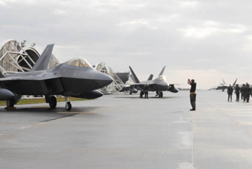 KADENA AIR BASE, Japan -- Crew chiefs park two F-22 Raptors from Langley Air Force Base, Va., after landing at Kadena Air Base, Okinawa, Japan on Sunday, 18 Feb 07. The jets are one of 12 that is currently deployed to Kadena as part of a previously scheduled deployment. It is the first overseas deployment for the Raptor.  (U.S. Air Force photo Airman Sheila deVera) 