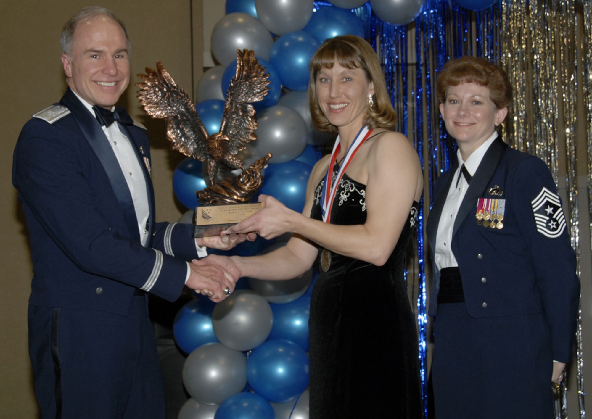 Brig. Gen. Richard Devereaux, 82nd Training Wing commander, and 82nd TRW Command Chief Chief Master Sgt. Jeannie McLean, present Dawn Loeffler of the 82nd Security Forces Squadron with her 2006 Entry-level Civilian of the Year award at the wing's award banquet Feb. 16. Ms. Loeffler was recognized for preparing 39 no-notice deployment orders for Airmen deploying to Kuwait and Iraq. She also processed over 14,000 records, meeting an astonishing 100 percent suspense rate. (U.S. Air Force photo/Sandy Wassenmiller)