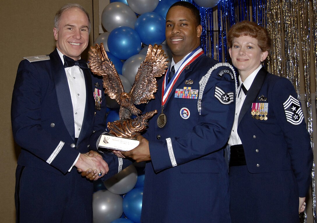 Staff Sgt. Dontrel Daniels, center, accepts his trophy Feb. 16 as the 82nd Training Wing's 2006 Senior Honor Guardsman of the year. The 82nd Training Group sergeant was recognized for experitise at performing different ceremonies, as well as directing 36 ceremonies, resulting in 220 man hours of work. Also pictured is Brig. Gen. Richard Devereaux, 82nd Training Wing commander, and Chief Master Sgt. Jeannie McLean, the wing's command chief. (U.S. Air Force photo/Sandy Wassenmiller)