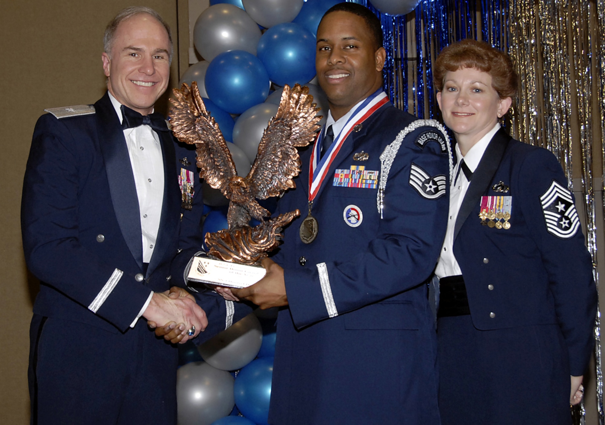 Staff Sgt. Dontrel Daniels, center, accepts his trophy Feb. 16 as the 82nd Training Wing's 2006 Senior Honor Guardsman of the year. The 82nd Training Group sergeant was recognized for experitise at performing different ceremonies, as well as directing 36 ceremonies, resulting in 220 man hours of work. Also pictured is Brig. Gen. Richard Devereaux, 82nd Training Wing commander, and Chief Master Sgt. Jeannie McLean, the wing's command chief. (U.S. Air Force photo/Sandy Wassenmiller)
