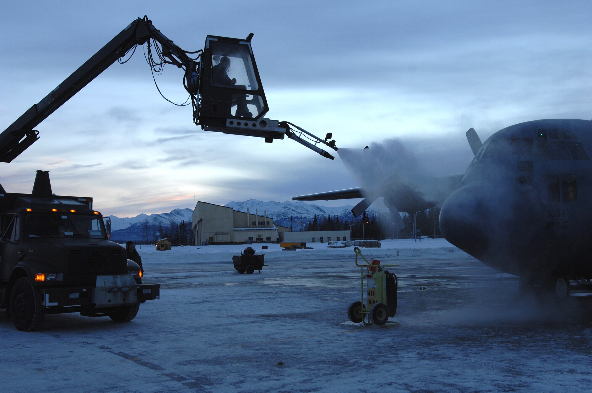 Senior Airman Steven Ferrin de-ices a C-130 Hercules Feb. 15 before it takes off from Elmendorf Air Force Base, Alaska, on a training mission.  Airman Ferrin is a crew chief for the 703rd Aircraft Maintenance Squadron and the C-130 belongs to the 517th Airlift Squadron.  (U.S. Air Force photo/Tech. Sgt. Keith Brown)