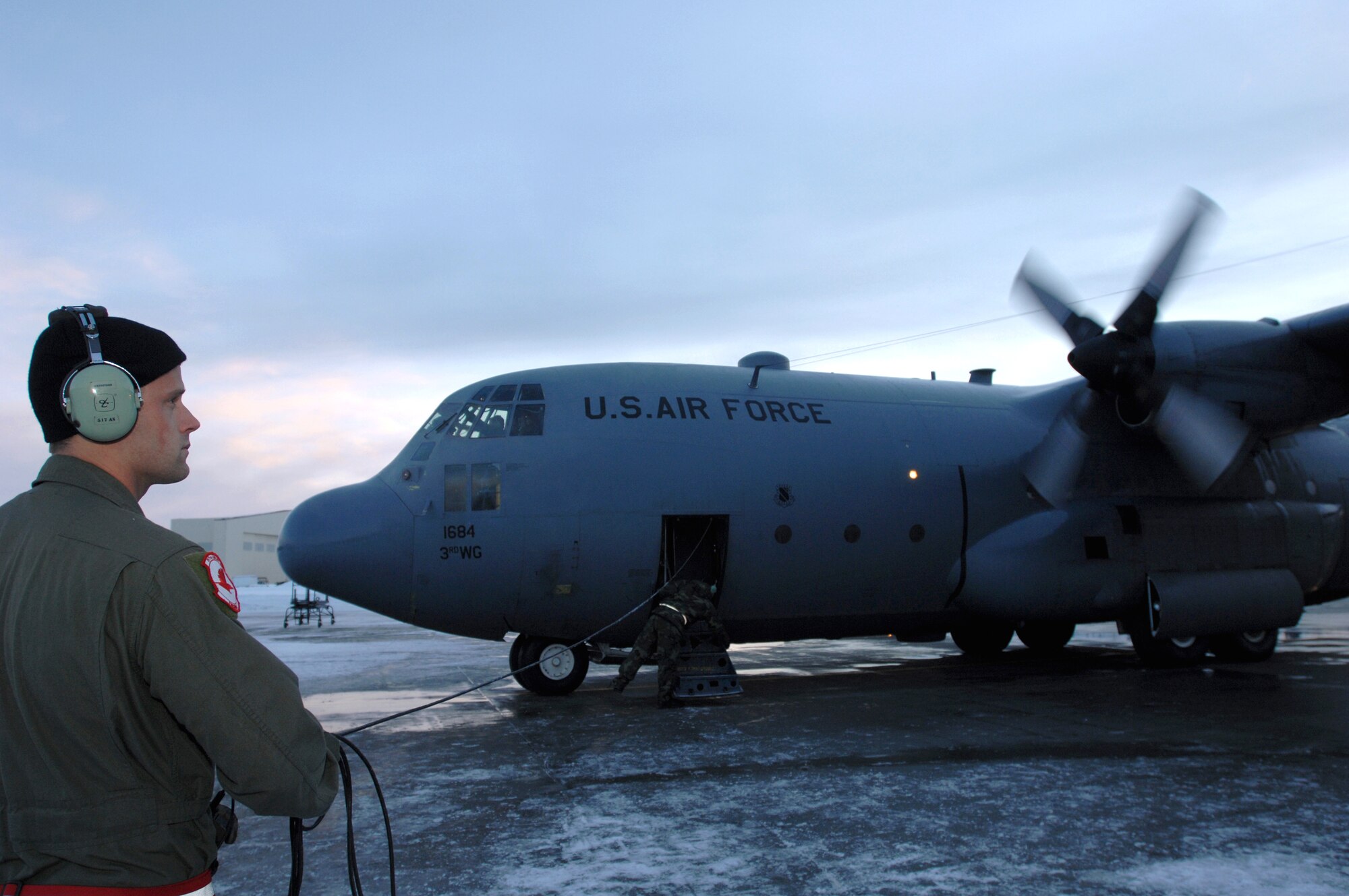 Senior Airman William Oxenford directs engine start-up on a C-130 Hercules Feb. 15 before it takes off from Elmendorf Air Force Base, Alaska, on a training mission.  Airman Oxenford is a load master with the 517th Airlift Squadron.  (U.S. Air Force photo/Tech. Sgt. Keith Brown)