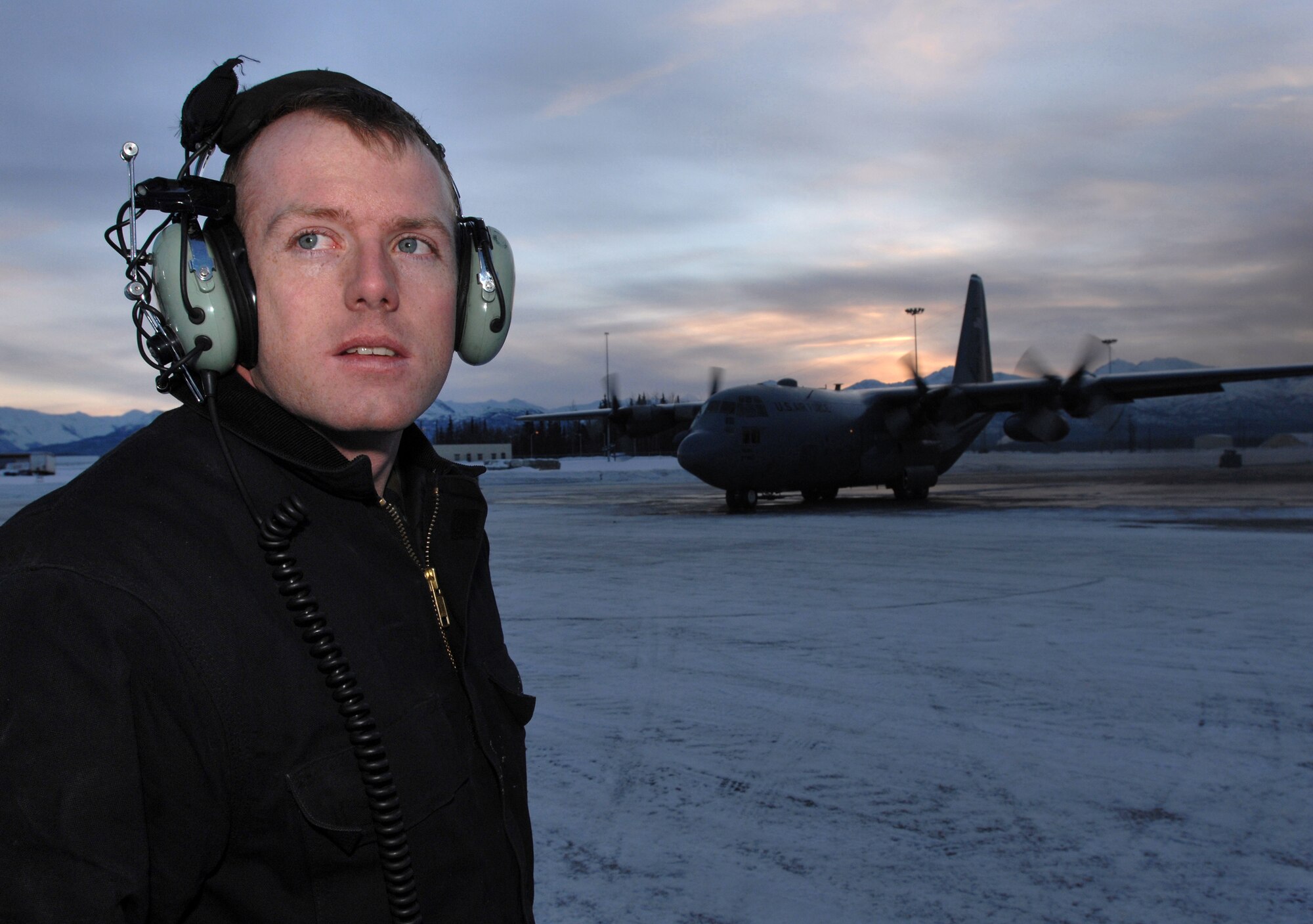 Senior Airman Steven Ferrin checks for hazards before marshalling out a C-130 Hercules for takeoff Feb. 15 from Elmendorf Air Force Base, Alaska. Airman Ferrin is a crew chief for the 703rd Aircraft Maintenance Squadron and the C-130 Hercules belongs to the 517th Airlift Squadron.  (U.S. Air Force photo/Tech. Sgt. Keith Brown)