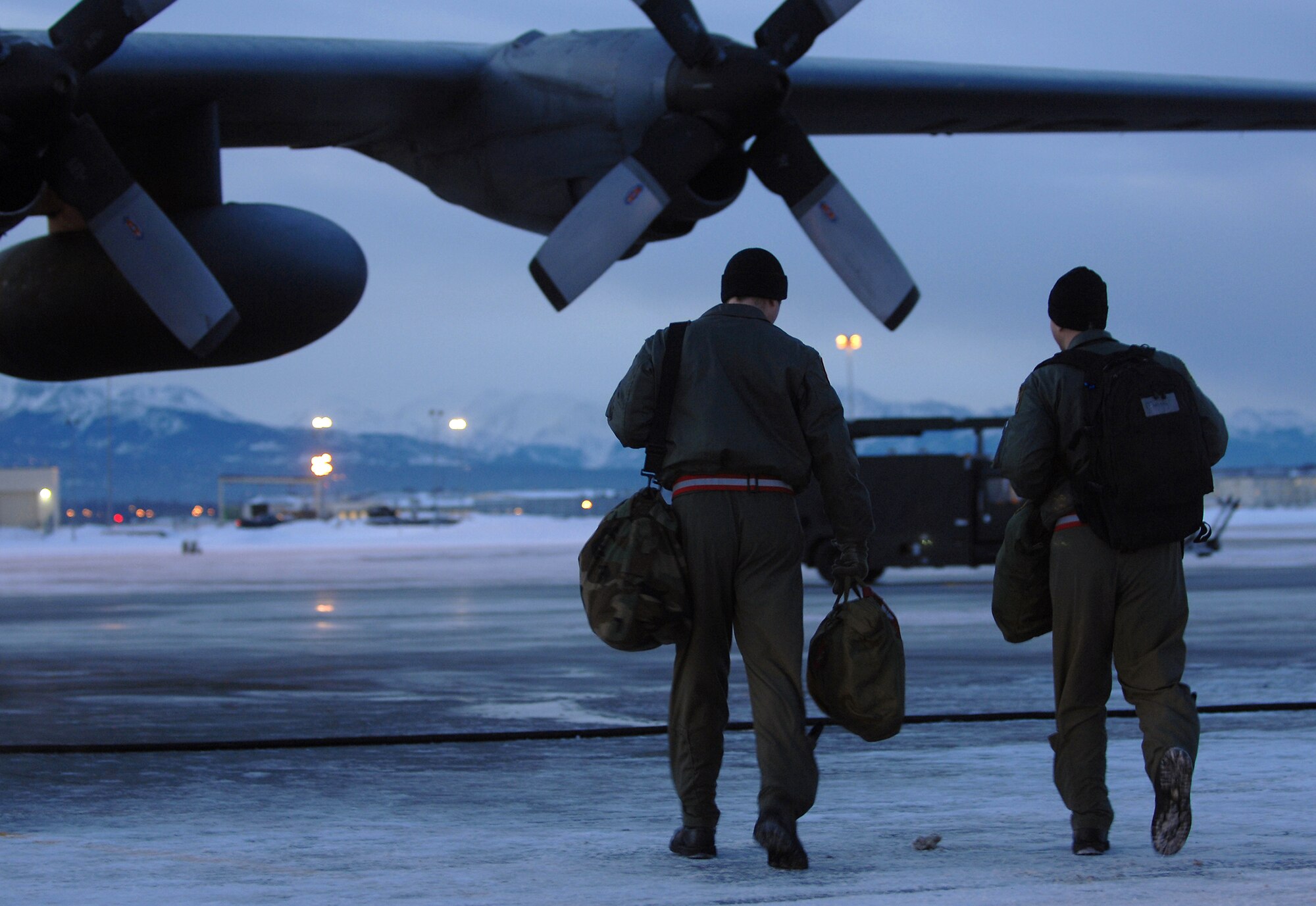 Two C-130 Hercules aircrew members walk to their aircraft before taking off on a training mission Feb. 15 from Elmendorf Air Force Base, Alaska. The crew members are assigned to the 517th Airlift Squadron.   (U.S. Air Force photo/Tech. Sgt. Keith Brown)