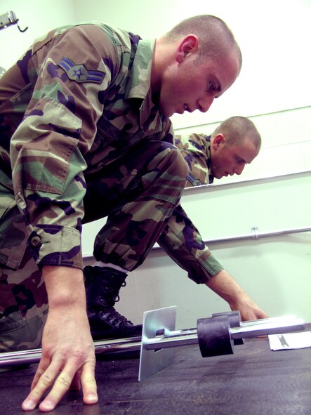 Airman 1st Class Patrick Totzke, 28th Services Squadron fitness specialist, pauses in the assembly process of a new universal machine for the family fitness room to consult instructions. The addition of the new machine is just part of the new look of the Ellsworth Bellamy Fitness Center’s recently renovated family room. The room reopened Feb. 6. (U.S. Air Force photo/Staff Sgt. Shanda L. De Anda)