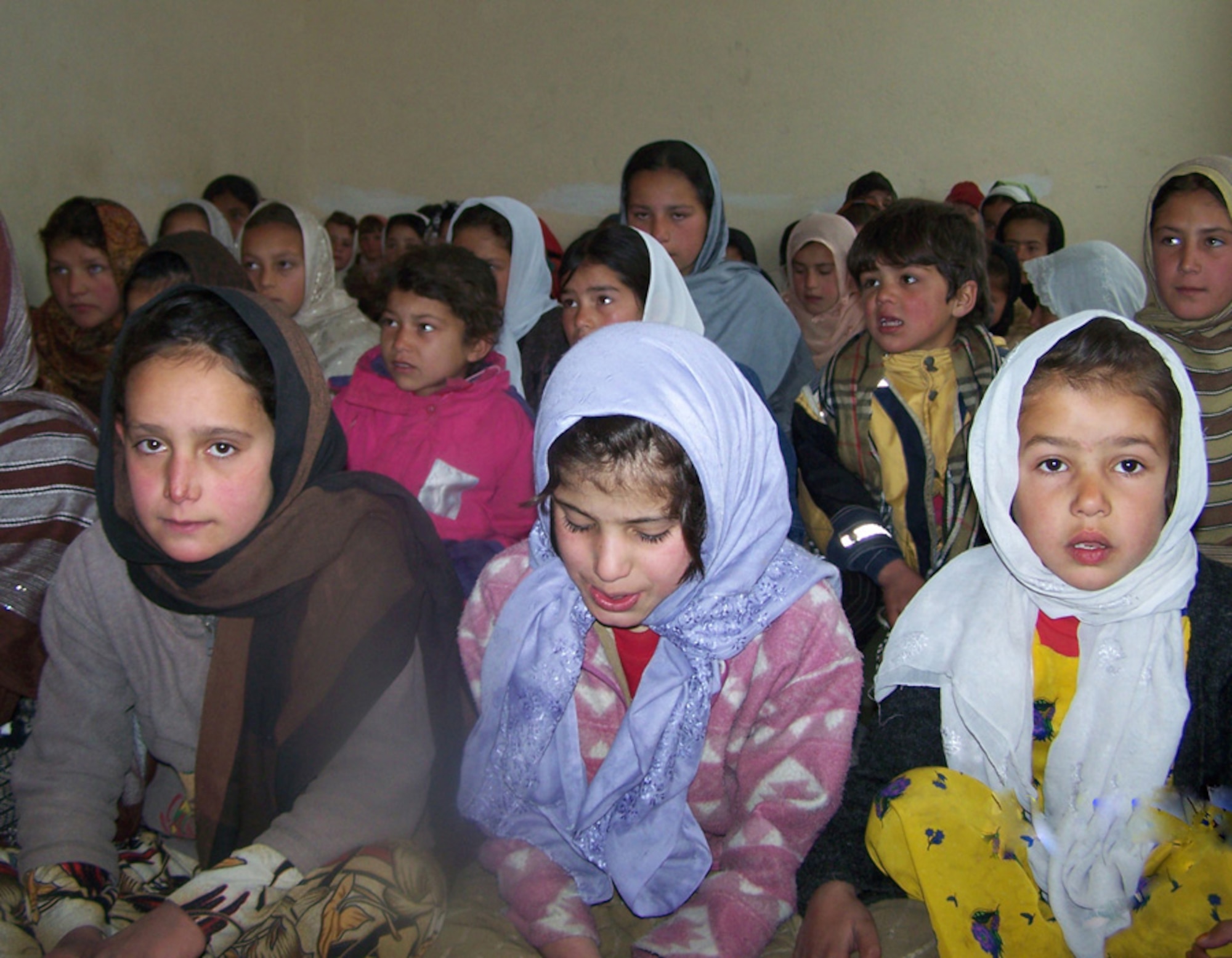 Students at the Tawakh Elementary School in Panjshir Province, Afghanistan wait patiently for school supplies to be passed out Feb. 18.  Members of the Panjshir Provincial Reconstruction Team and volunteers delivered student kits to many of the school's 350 children who were in attendance. (Courtesy Photo by Navy Petty Officer 1st Class Kelly Harrell).