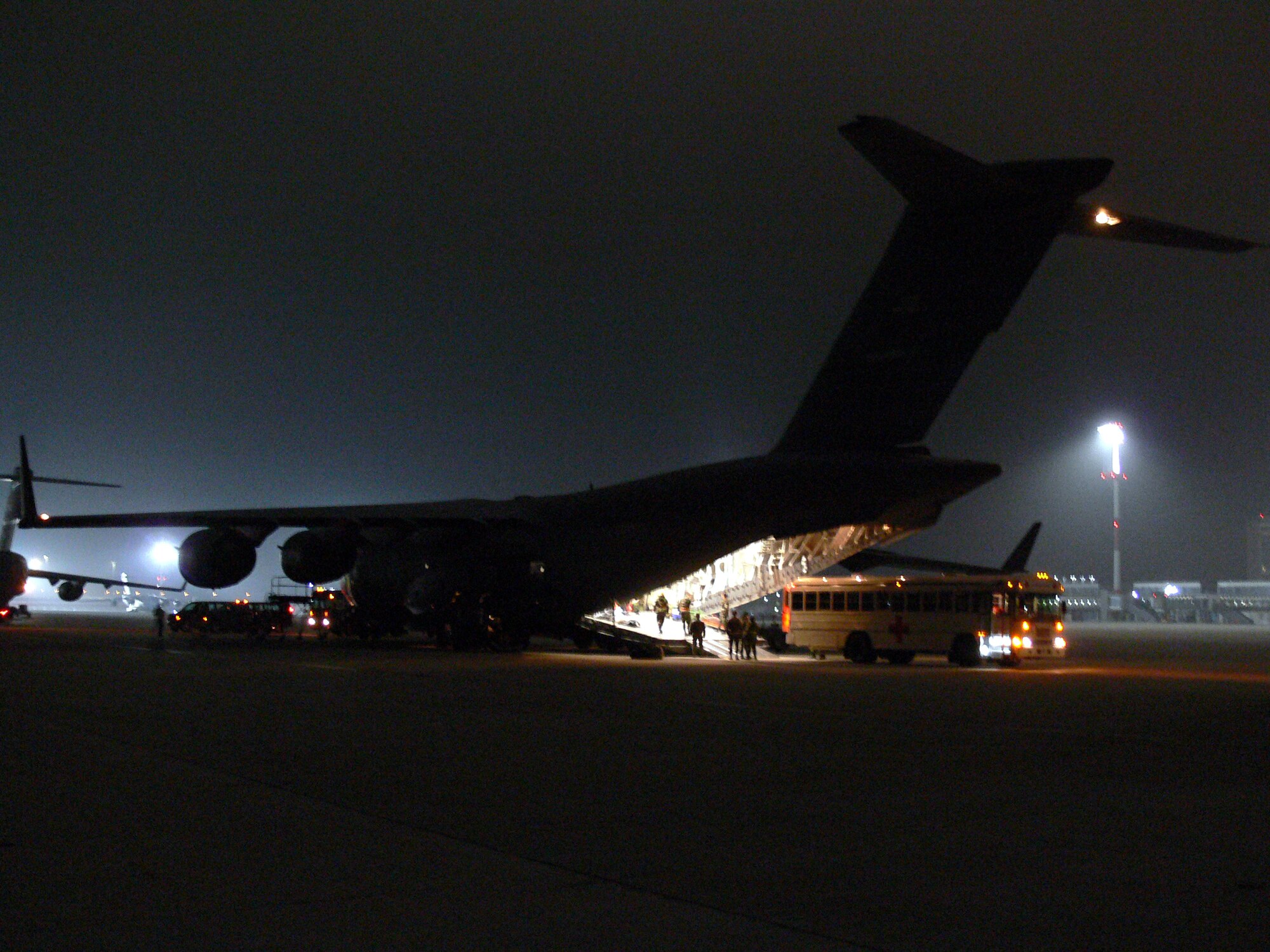 Twenty members of the 435th Aeromedical Staging Flight from Ramstein Air Base, Germany unload critical patients from an arriving C-17.  The aircraft contained 11 wounded troops that survived a fatal helicopter crash in Southeast Afghanistan only hours earlier.  Once loaded on the busses, the wounded were taken to Landstuhl Regional Medical Center.