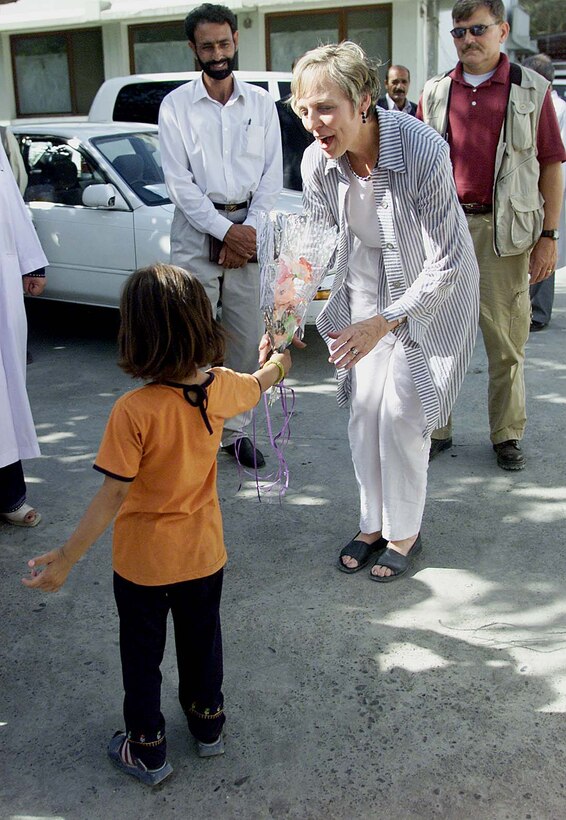 An Afghan girl presents flowers to Mary Jo Myers, spouse of Joint  Chiefs chairman Air Force Gen. Richard Myers, during her tour of a women's  hospital and orphanage in Kabul, Afghanistan, July 30. "You have a lot of people  here who care for you and a lot of people in the U.S. who want to help, so don't  you worry," she told a young Afghan boy at the orphanage. Photo by Sgt.  Stephanie Hall.