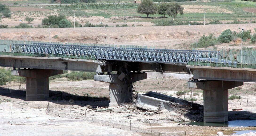 During the war in Iraq, U.S. Air Force bombers used precision  munitions to drop this bridge, near a Saddam Hussein palace in Tikrit, in two  places. After major combat operations ended, U.S. Army engineers used military  bridging equipment to repair the damage. Photo By Jim Garamone