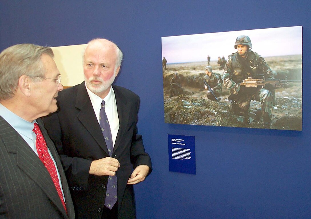 David Hume Kennerly, former personal photographer for President  Gerald Ford and Pulitzer Prize winner, escorts Secretary of Defense Donald  Rumsfeld through the "A Day in the Life of the United States Armed Forces"  photography exhibit at the Women's Memorial May 8. Photo by Rudi Williams