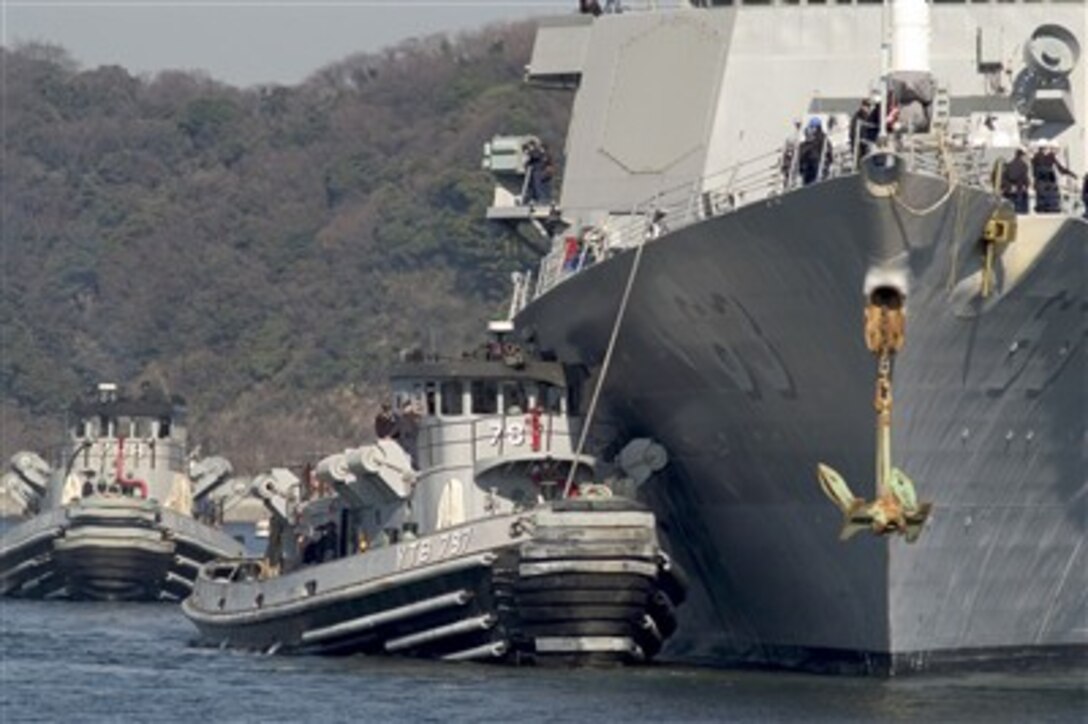 Tugboats nestle alongside and guide the USS Stethem (DDG 63) as it pulls into Commander Fleet Activities Yokosuka, Japan, on Feb. 12, 2007.   The Arleigh Burke-class guided-missile destroyer is returning to Yokosuka after completing two weeks of drills at sea.  