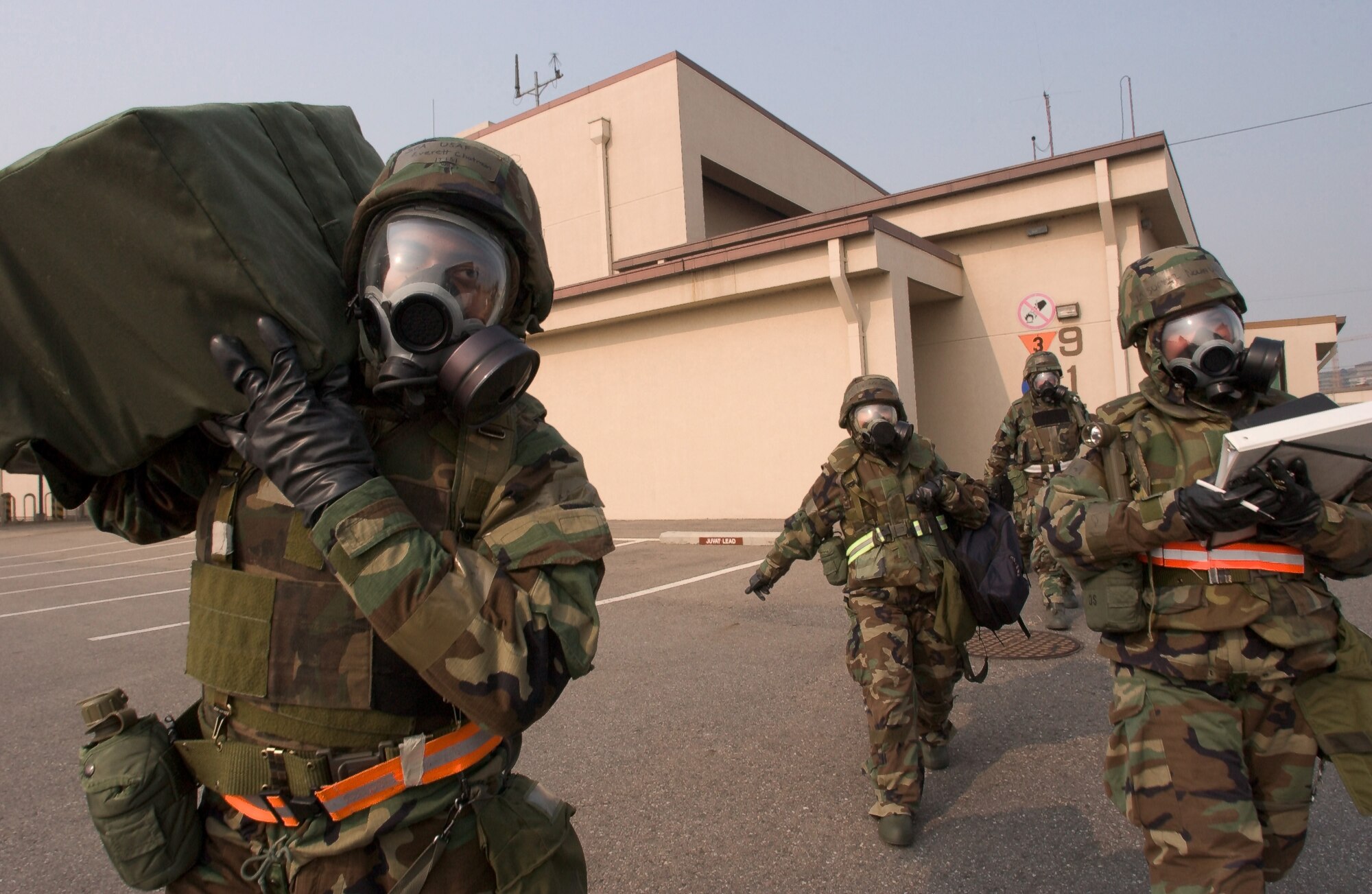Members of the 80th Fighter Squadron, Kunsan AB, Republic of Korea, evacuate to an alternate location after their workcenter is damaged during a simulated chemical attack on Wednesday, February 21, 2006.  (U.S. Air Force Photo/Senior Airman Barry Loo)