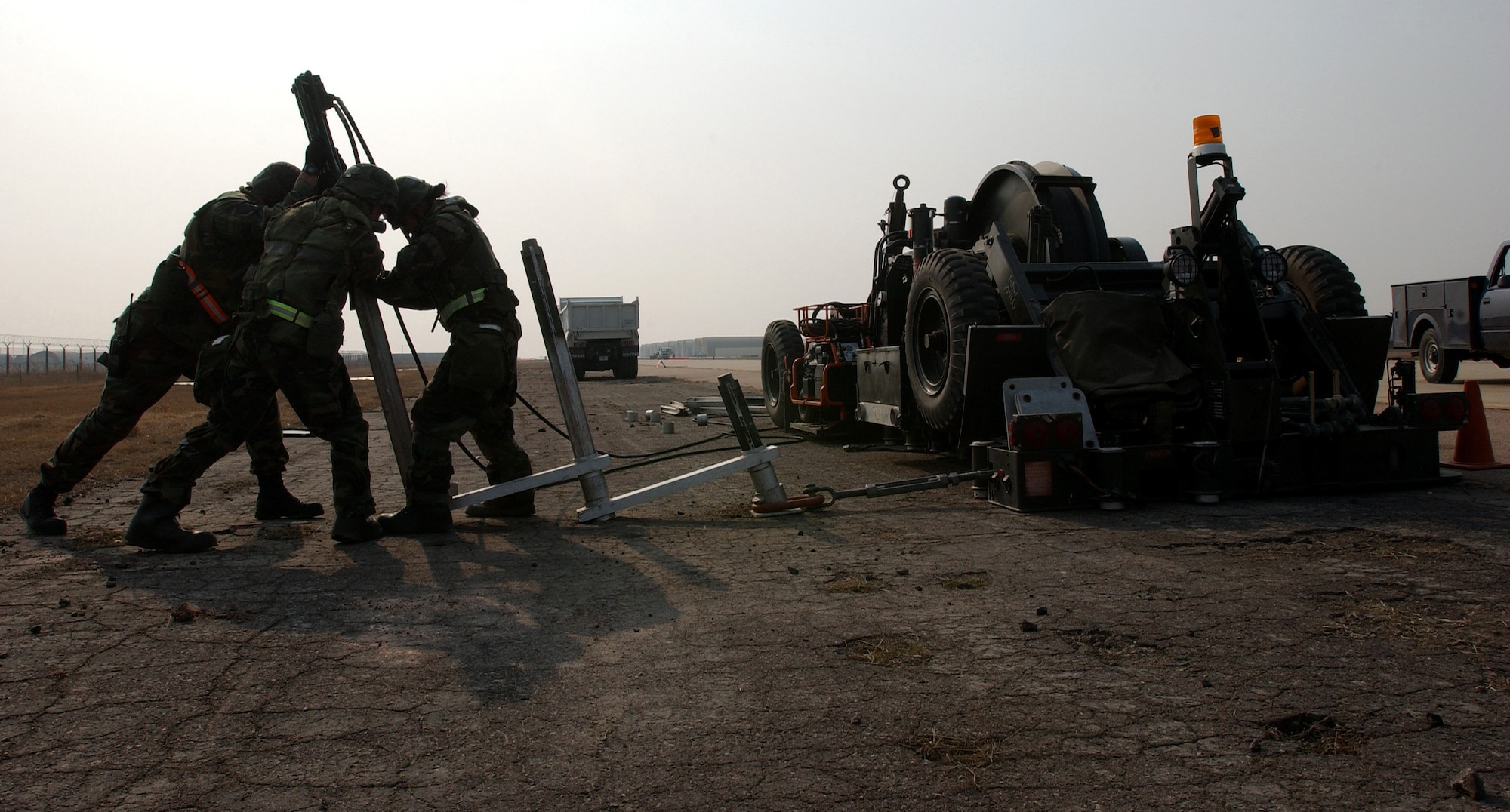 Members of the 8th Civil Engineering Squadron Airfield Damage Repair (ADR) team, install anchors in the Mobile Aircraft Arresting System (MAAS), Wednesday, February 21, 2007.  The MAAS contains the cable used to stop damaged aircraft that cannot stop on their own during landing.  ADR teams do everything from crater repair to airfield lighting making it possible to get aircraft back in the air quickly. (U.S. Air Force Photo/Master Sgt Jack Braden)
