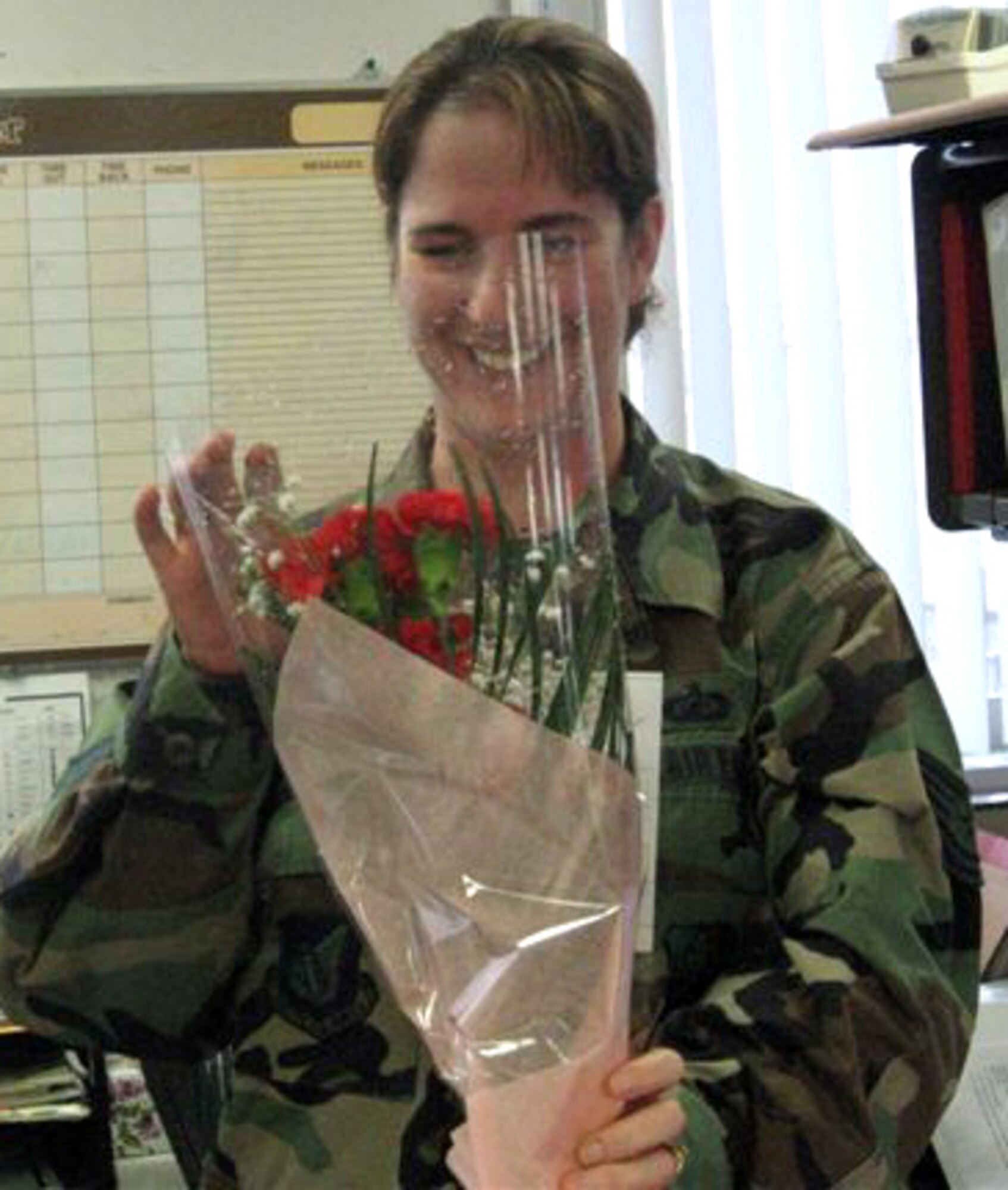 070214 -- MISAWA AIR BASE, Japan -- Tech. Sgt. Colleen Beverly, 35th Comptroller Squadron, receives a bouquet of flowers from her husband Tech. Sgt. Phillip Beverly, 35th Aircraft Maintenance Squadron, who is deployed to Iraq. Volunteers from his squadron delivered 30 personalized cards, 230 roses and 89 carnations to help make the day special for wives, girlfriends and children of deployed Airmen. (Courtesy photo)