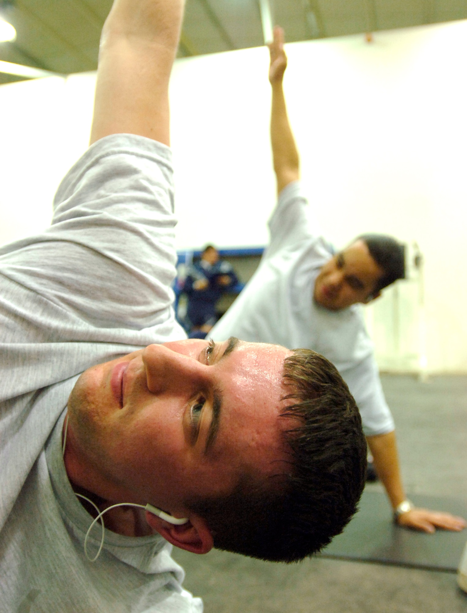 Master Sgt. Marlon Carcamo (left) and Senior Airman Jacalyn Albert stretch it out during an intense abs class Feb 13 in the gym at Balad Air Base, Iraq. Sergeant Carcamo is assigned to the 332nd Expeditionary Logistics Squadron. Airman Albert is assigned to the 332nd Expeditionary Maintenance Squadron. (U.S. Air Force photo/Tech. Sgt. Cecilio M. Ricardo Jr.)