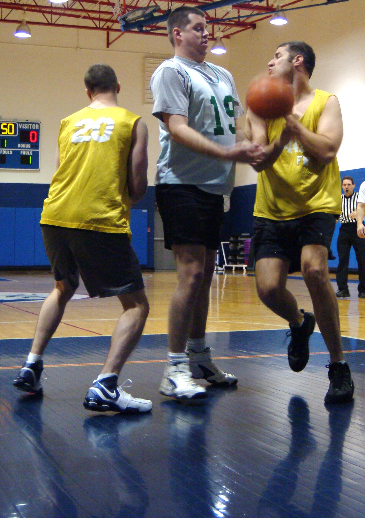 John Schriever drives to the basket around a defender for a score while Keith Yersak, number 20, sets a screen during the Whiteman Air Force Base over-30 intramural basketball championship Feb. 15.  Schriever and Yersak, along with the rest of the 442nd Fighter Wing team beat the squad from the 509th Security Forces Squadron 41-32 to claim the team's fourth base title in five years. (U.S. Air Force photo/Maj. David Kurle)