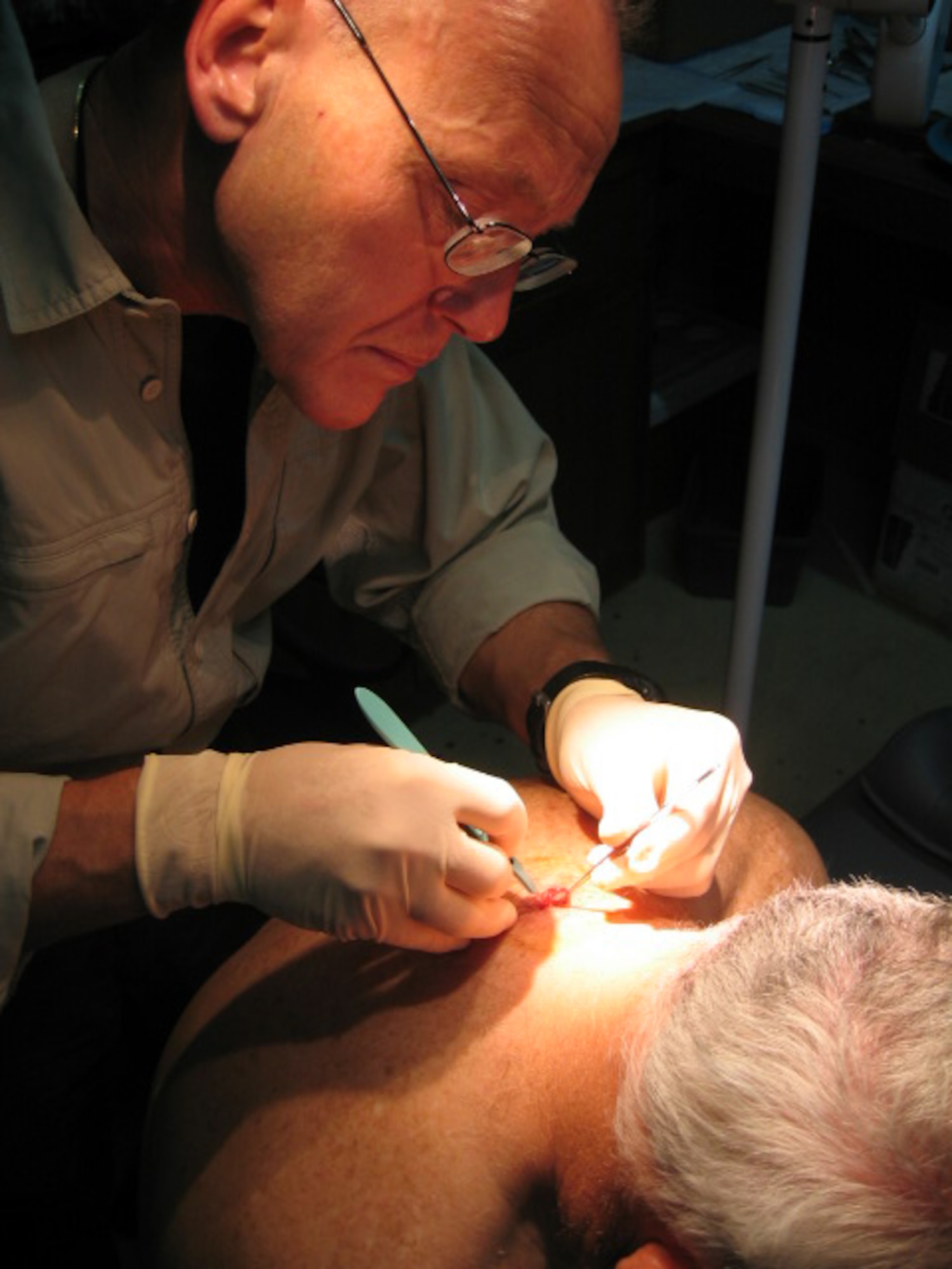 Dr. Michael Ripley removes a cyst from a patient’s back while serving as a civilian doctor at Baghdad International Airport in 2005. Dr. Ripley, 51, joins the active-duty Air Force in March to which he’ll contribute extensive experience in deployed medicine and leadership skills. For 2007, the Air Force seeks more than 1,000 fully-qualified recruits for medical service corps, dental corps, nurse corps and biomedical corps specialties. For more information, visit www.airforce.com. (Courtesy photo)