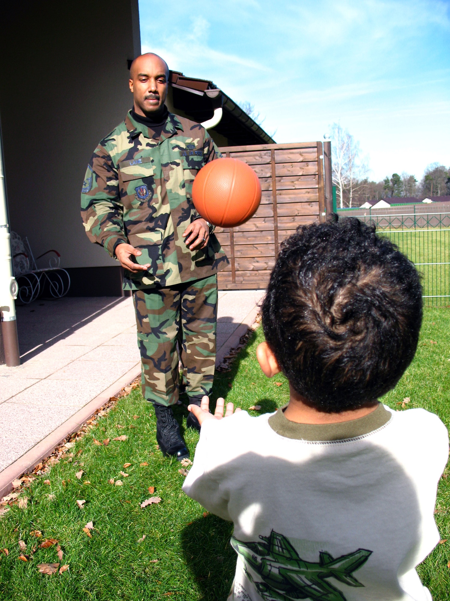 Master Sgt. Michael Lane plays with his son Jaylin in their backyard in base housing Feb. 16 at the Kaiserslautern Military Area in Germany. The yard is one of many features in the new base housing. Contractors are building more than 1,000 townhomes in the Kaiserslautern Military Area. The $500 million project is scheduled to be completed by 2010. Sergeant Lane is assigned to the 435th Civil Engineering Squadron. (U.S. Air Force photo/Staff Sgt. Laura Holzer) 
