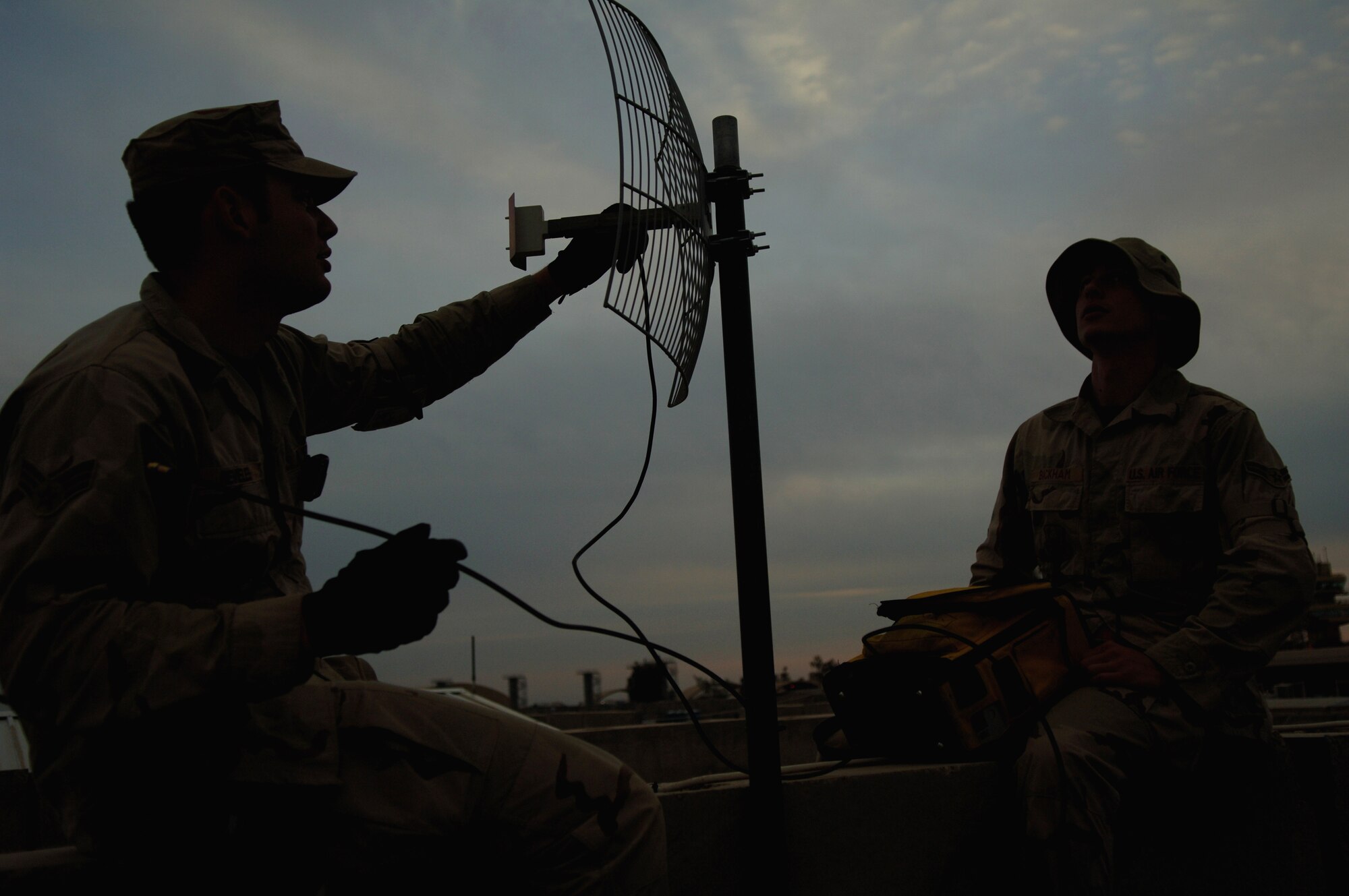Senior Airman Ricardo Reveles and Airman 1st Class Sven Bickham install an antenna and align a satelite dish for the best signal Feb. 17, at Balad Air Base, Iraq.  The Airmen are 332nd Communications Squadron satellite journeyman and support 50 installations in the region.  (U.S. Air Force photo/Airman 1st Class Nathan Doza)