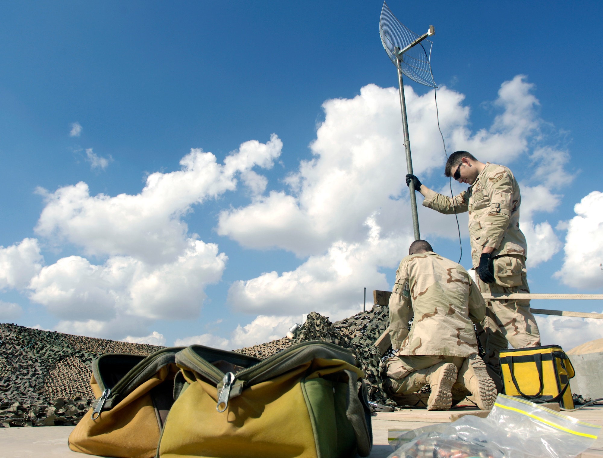 Senior Airman Ricardo Reveles and Airman 1st Class Sven Bickham install an antenna and align a satelite dish for the best signal Feb. 17 at Balad Air Base, Iraq. The Airmen are 332nd Expeditionary Communications Squadron satelite communication journeyman and support 50 installations in the region. (U.S. Air Force photo/Airman 1st Class Nathan Doza)

