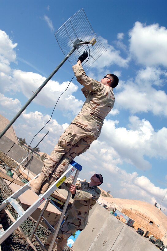 Senior Airman Ricardo Reveles and Airman 1st Class Sven Bickham install an antenna and align a satelite dish for the best signal Feb. 17 at Balad Air Base, Iraq. The Airmen are 332nd Expeditionary Communications Squadron satelite communication journeyman and support 50 installations in the region. ( U.S. Air Force photo/Airman 1st Class Nathan Doza)