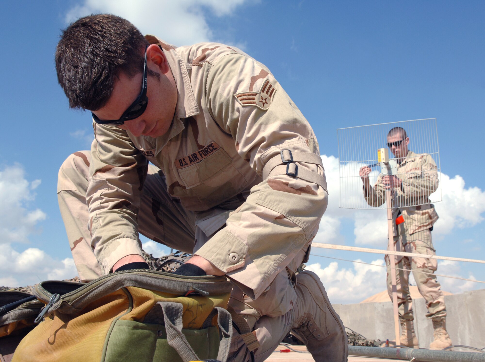 Senior Airman Ricardo Reveles and Airman 1st Class Sven Bickham install an antenna and align a satelite dish for the best signal Feb. 17 at Balad Air Base, Iraq. The Airmen are 332nd Expeditionary Communications Squadron satelite communication journeyman and support 50 installations in the region. ( U.S. Air Force photo/Airman 1st Class Nathan Doza)
