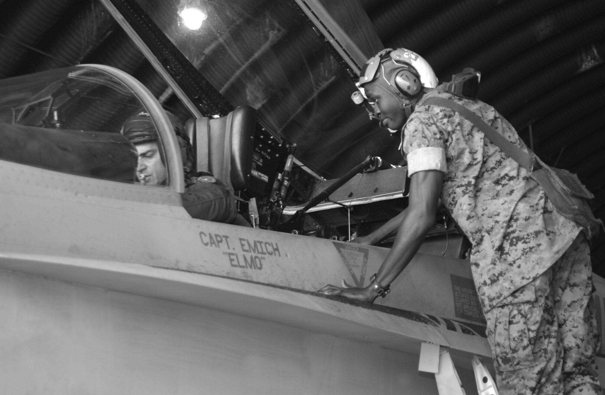 OSAN AIR BASE, Republic of Korea --  Lance Cpl. Reuben Odoi, plane captain, helps Maj. Clay “Jungle” Berardi prepare the cockpit for start up. (U.S. Air Force photo by Airman 1st Class Gina Chiaverotti)