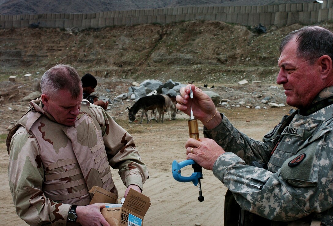 U.S. Air Force Maj. Sam Barringer and Army Col. Sydney McDaniel show Afghan veterinarians how to use new medicines during a conference in Asadabad, Afghanistan, Feb. 5, 2007.