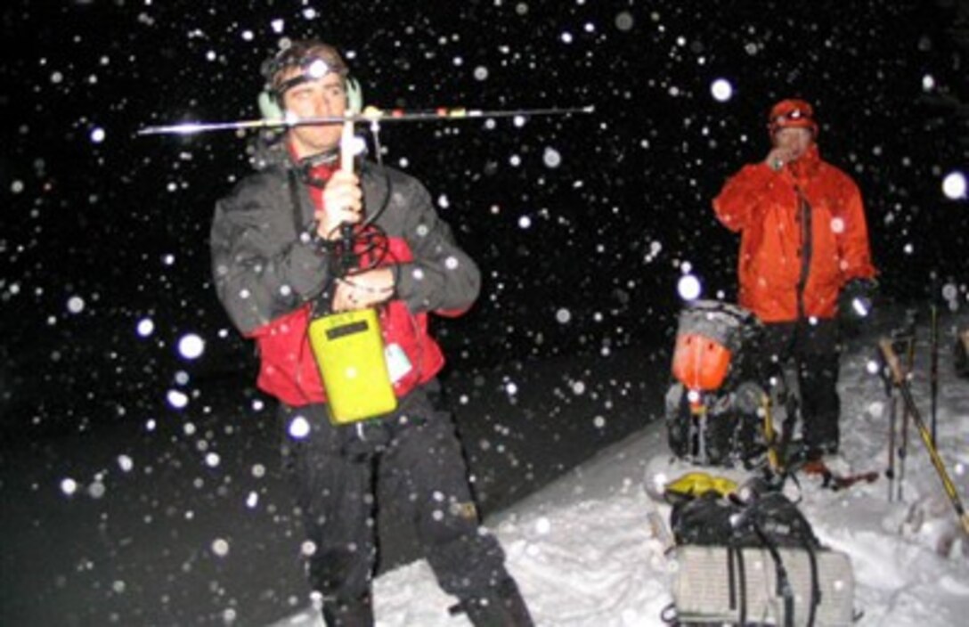 Staff Sgt. Josiah Blanton uses a directional antenna to locate a beacon signal from a mountain locator unit during a search for three missing climbers at Mount Hood, Ore, Feb 18, 2007. Once he finds the signal, he marks the location and radios it into the command post to be plotted on a map. 