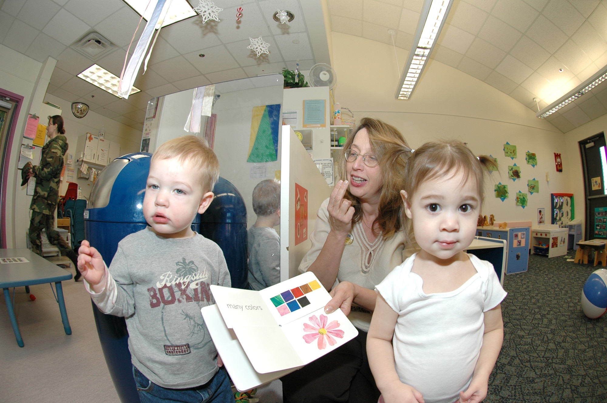 Nancy Keeton, training and curriculum specialist, demonstrates the signs for various animals while working with Hunter Shull, son of Capt. Robert Shull, 92nd Air Refueling Squadron, and Capt. Ashley Shull, 92nd Operations Support Squadron, at Fairchild Air Force Base, Wash. (Photo by Staff Sgt. Kristian Carter)
