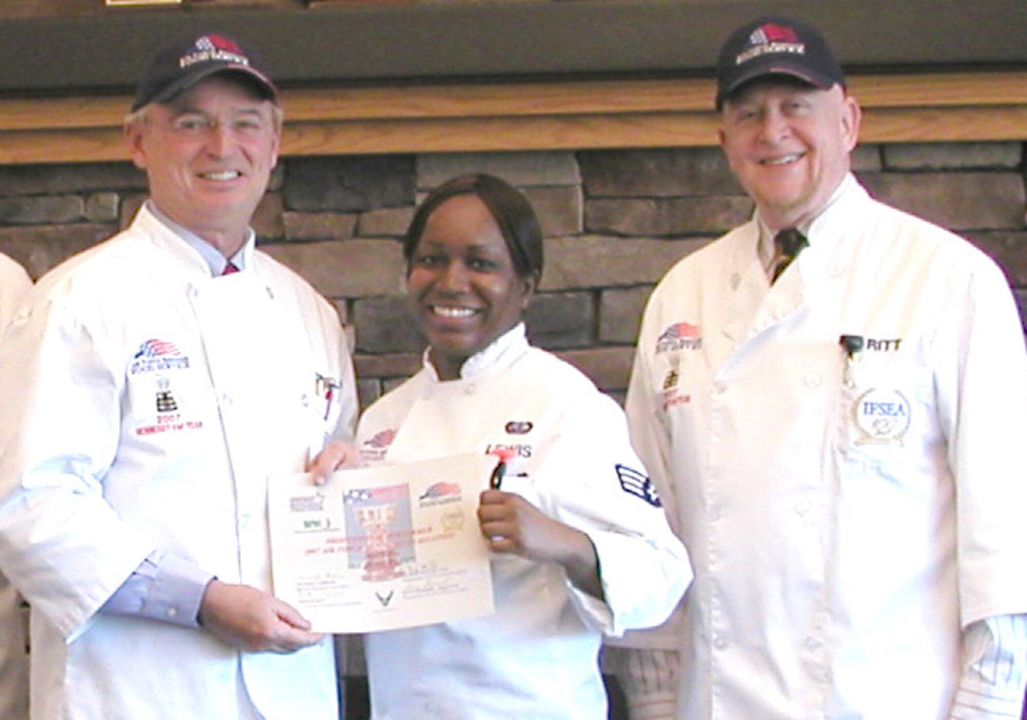 Michael Gibbons (left), National Restaurant Association, and Art Ritt, International Food Services Executives Association, present Senior Airman Donice Lewis, Warrior Inn midnight shift leader, with a Professional Performer Award certificate. Mr. Gibbons and Mr. Ritt, both John L. Hennessy evaluators, visited Fairchild this week to evaluate the 92nd Services Squadron’s food services operations. (Courtesy photo) 
