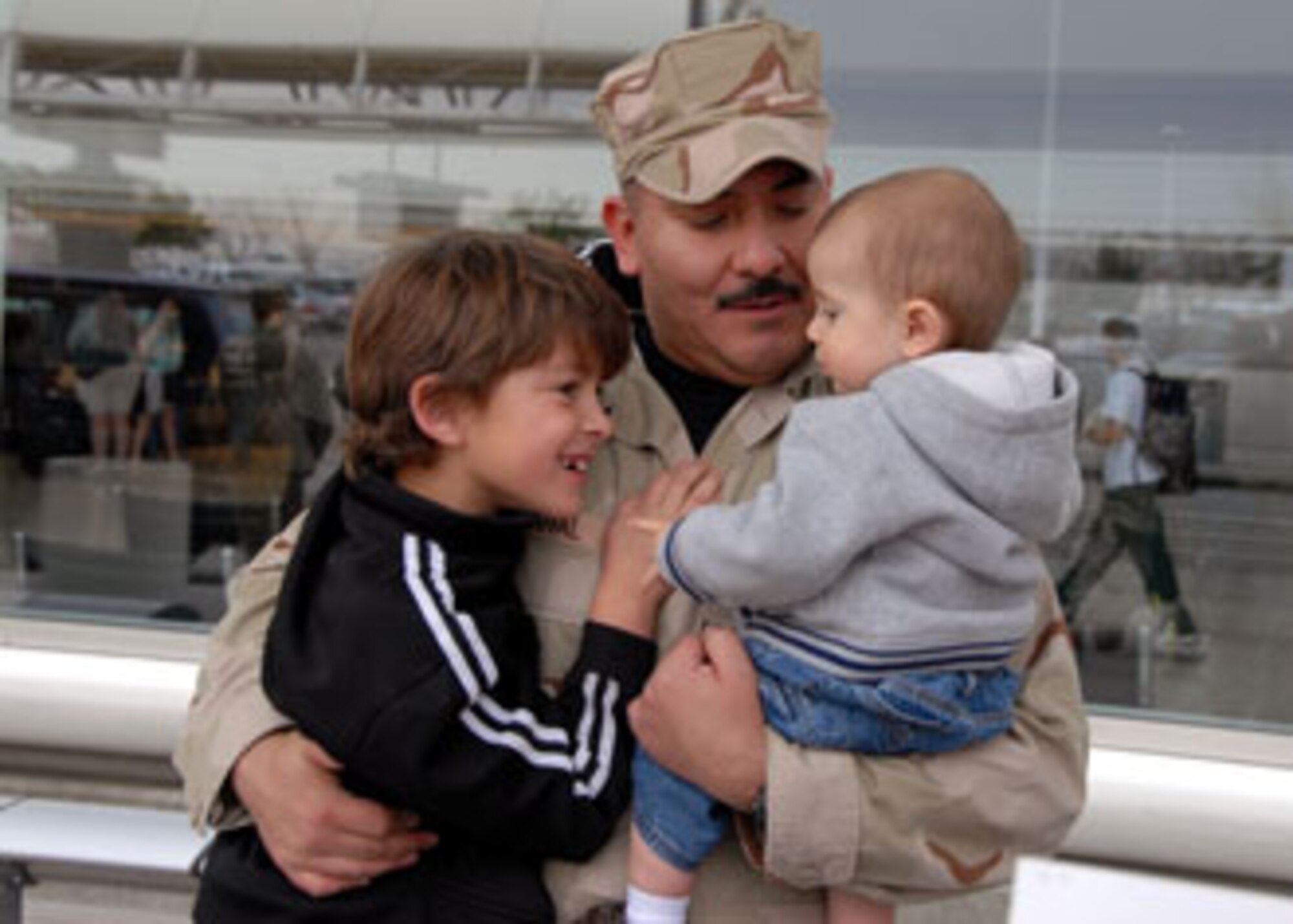 Senior Master Sgt. Tony Sandoval, 163rd Reconnaissance Wing, hugs his children  and at the Ontario Airport January 31 after returning home from a four month long deployment to Manas AB. (U.S. Air Force photo by Senior Airman Diane Ducat)