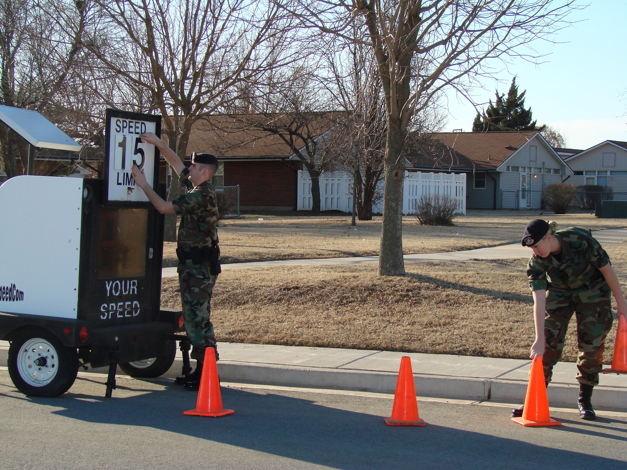 Airman 1st Class Michael Moore and Airman First Class Tina Ernsting with the 71st Security Forces Squadron install a Speed Cart in Vance military family housing Feb. 22. The Speed Cart shows drivers how fast their vehicles are traveling in an effort to deter speeding. (U.S. Air Force Photo by 2nd Lt. Agneta Murnan)
