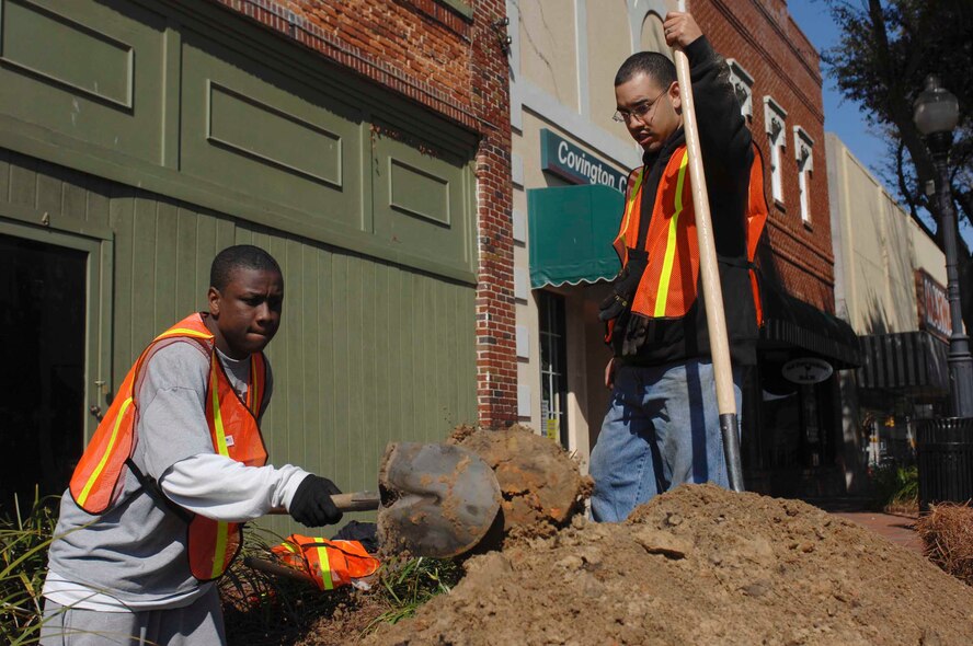 SUMTER, S.C. -- Senior Airmen Kerwin Whitfield and Armando Largaespada, assigned to the 20th Component Maintenance Squadron at Shaw Air Force Base, S.C., dig holes for a landscaping project Feb. 16 in downtown Sumter as part of the "Put the 'U' in Sumter" campaign. More than 600 Shaw Airmen and civilian employees and their families planted trees and shrubs, completed painting projects, power washed historic buildings, and landscaped flower beds and did some general clean up at various locations in Sumter. (U.S. Air Force photo/Airman 1st Class Matthew Davis) 