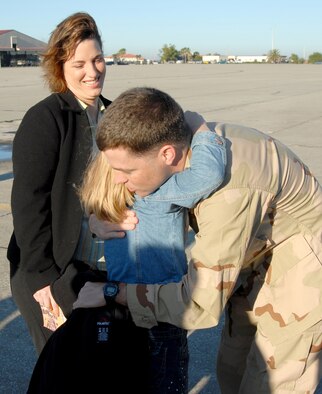 A  920th Rescue Wing Airman hugs his daughter while his wife looks on prior to deploying to the Horn of Africa