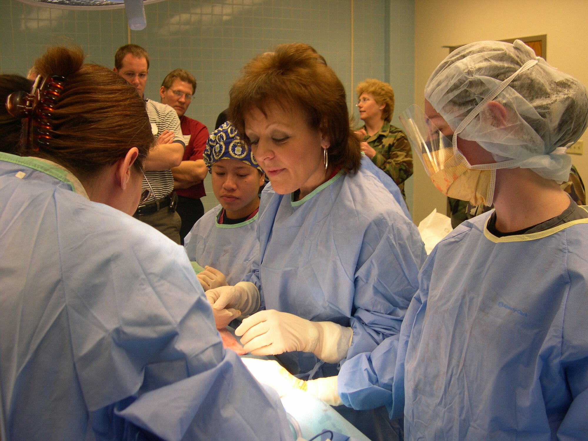Tawana Thomas, center, assists with an appendectomy in the 882nd Training Group's Surgical Services Apprentice Course Feb. 20 during the annual Leadership Wichita Falls tour. Touring Sheppard is part of the groups course that allows them to learn about government, public safety, emergency management, educational services and etiquette. (U.S. Air Force photo/Debi Smith)