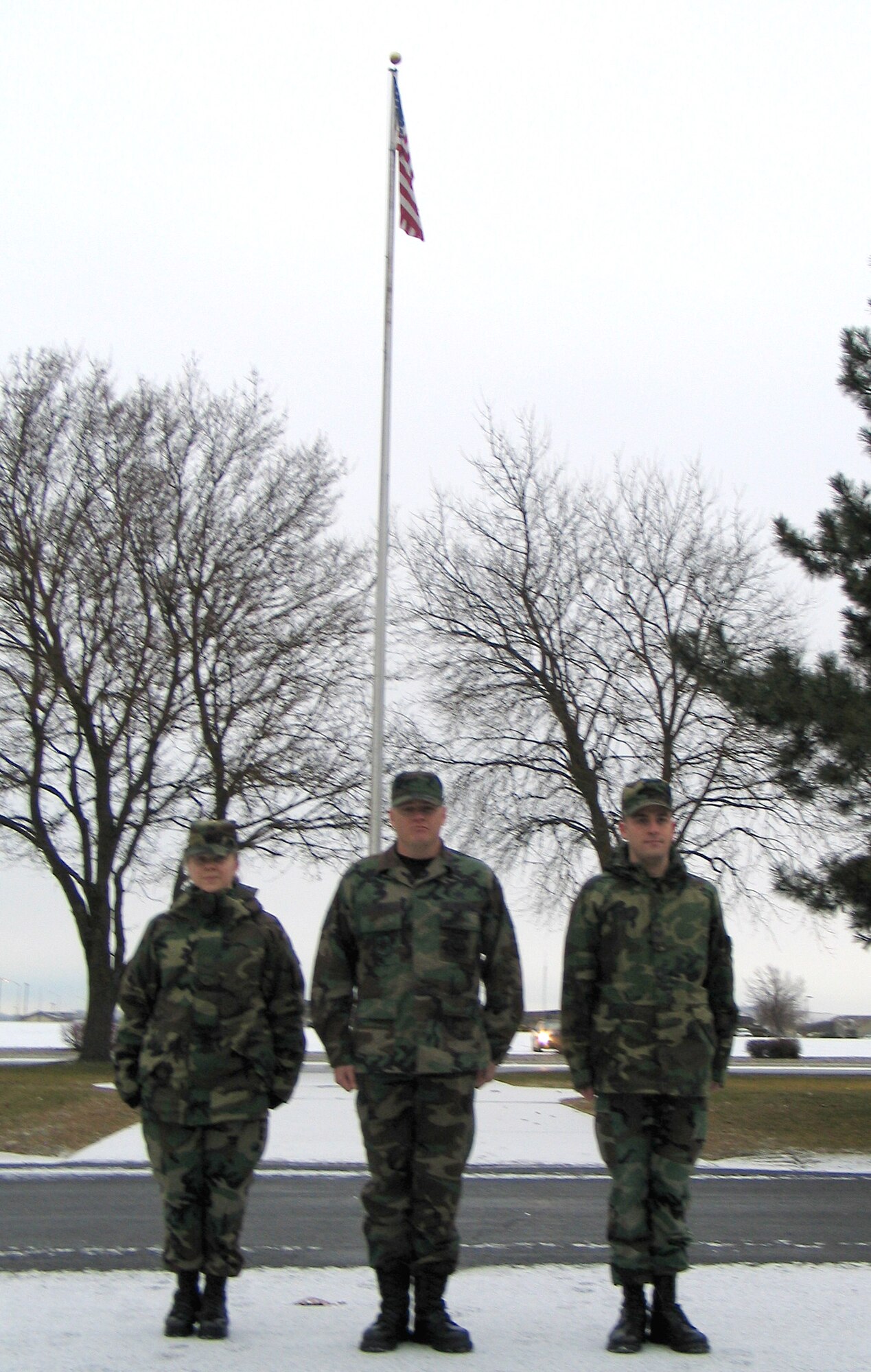 FAIRCHILD AIR FORCE BASE, Wash. -- After posting the American flag Thursday morning in front of the 92nd Air Refueling Wing headquarters building, Airman 1st Class Jocelyn Ford (left), Tech. Sgt. Michael Jones and Senior Airman Anthony Ennamorato stand at attention before being released. (Photo by Staff Sgt. Connie L. Bias)
