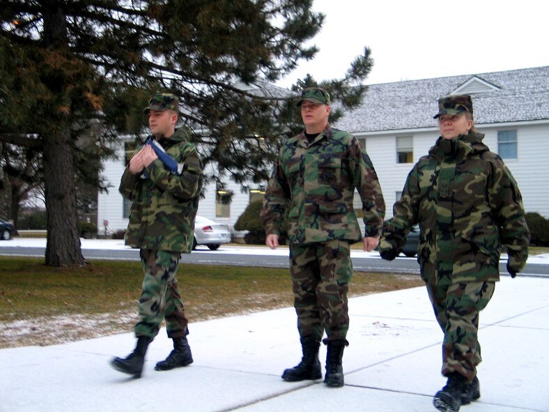 FAIRCHILD AIR FORCE BASE, Wash. -- From left, Senior Airman Anthony Ennamorato, Tech. Sgt. Michael Jones and Airman 1st Class Jocelyn Ford, 92nd Air Refueling Squadron Communications Squadron, prepare to post the American flag at reveille Thursday in front of wing headquarters. (Photo by Staff Sgt. Connie L. Bias)