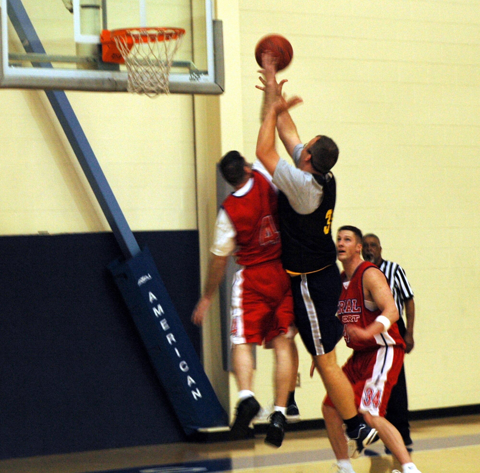 Daniel Reynoso, (#4), 60th Aerial Port Squadron’s shooting guard, and Zack Kent, (black shirt), 60th Medical Operations Squadron’s power forward, battle for a rebound during the 60th APS’ 49-44 win over the 60th MDOS Feb. 20. (U.S. Air Force photo by Staff Sgt. Candy Knight)