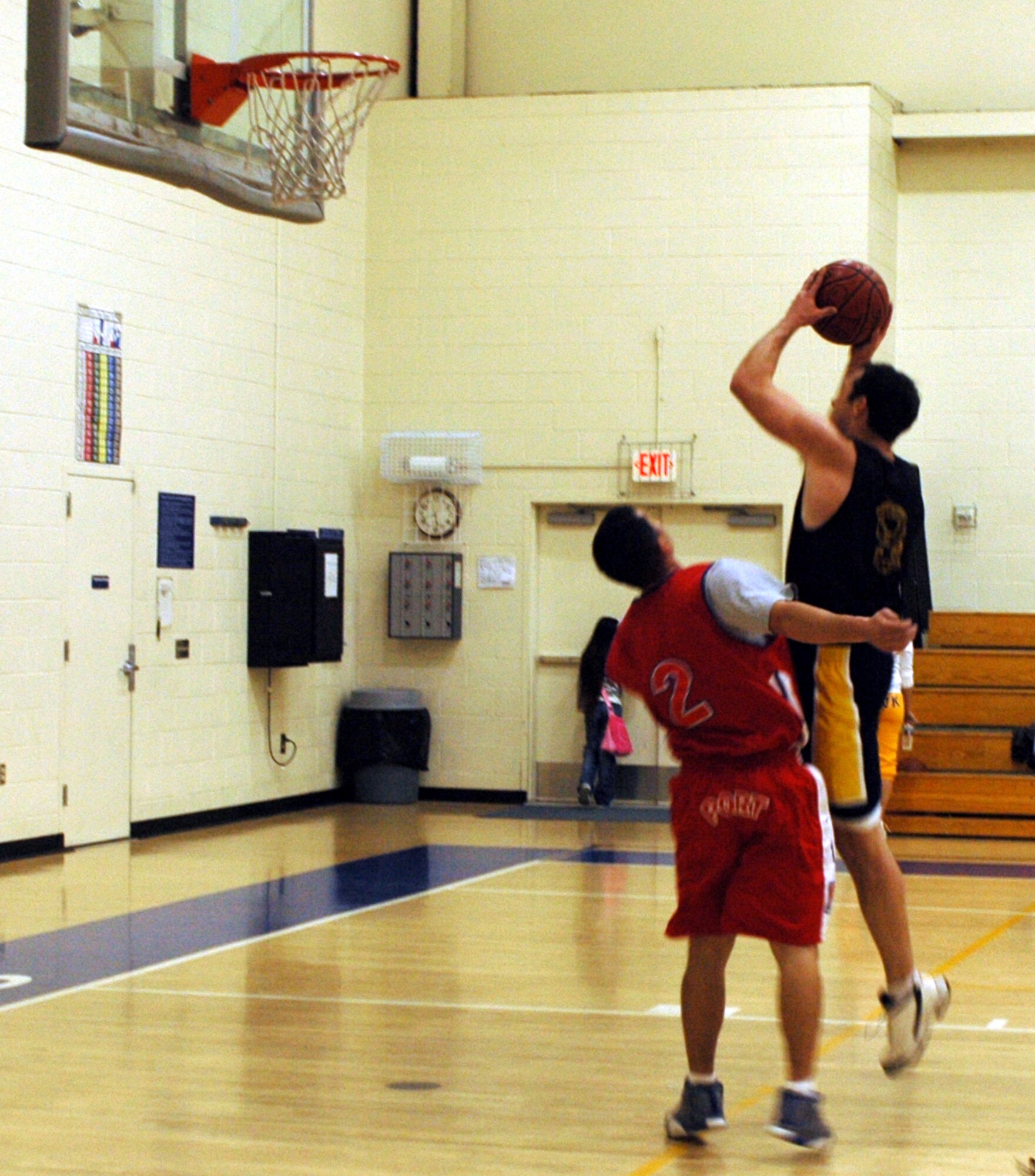 Lance McAdams, (with ball), 60th Medical Operations Squadron’s point guard, attempts a jump shot over Jesus Calderon, 60th Aerial Port Squadron shooting guard, during their game Feb. 20. The 60th APS won 49-44. (U.S. Air Force photo by Staff Sgt. Candy Knight)