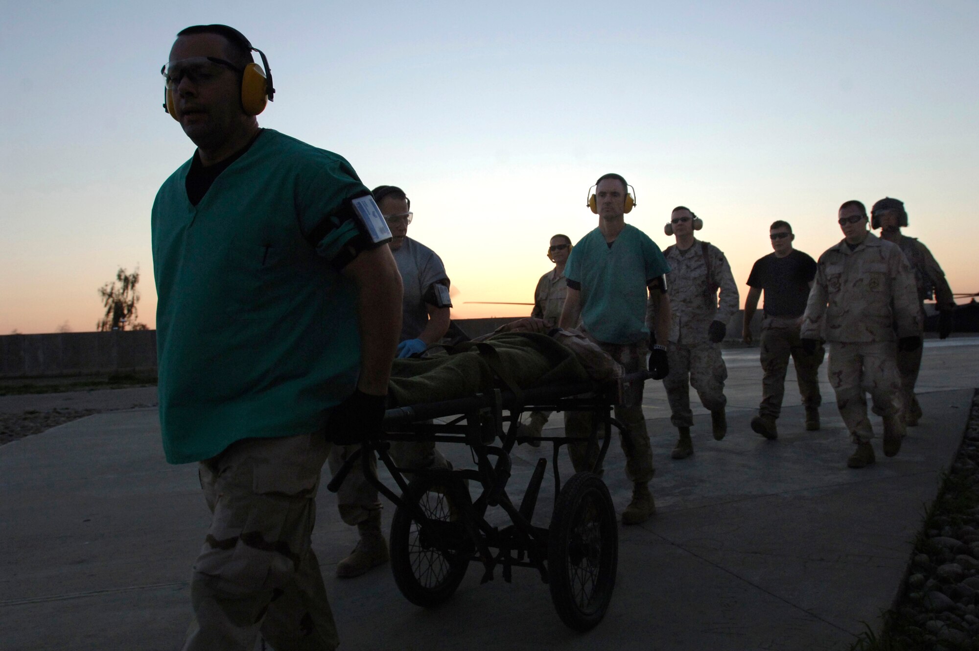 Medics transport a patient toward the Air Force Theater Hospital at Balad Air Base, Iraq.  As nightfall approaches, 39 patients had been treated at the hospital that day.  The medical facility, protected by towering barriers, is has a survival rate of 98 percent. (U.S. Air Force photo/Tech. Sgt. Cecilio M. Ricardo Jr.)