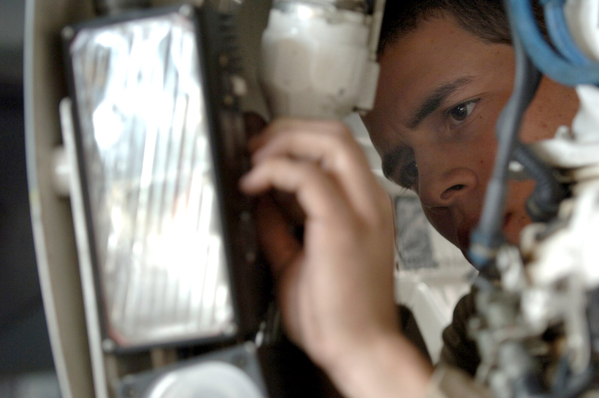 Airman 1st Class Kyle Guidry, 332nd  Expeditionary Aircraft Maintenance Squadron,  replaces the nose landing gear light on an F-16 at Balad Air Base, Iraq.  Airman Guidry is deployed from Aviano Air Base, Italy. (Photo by Staff Sgt. Michael Holzworth)