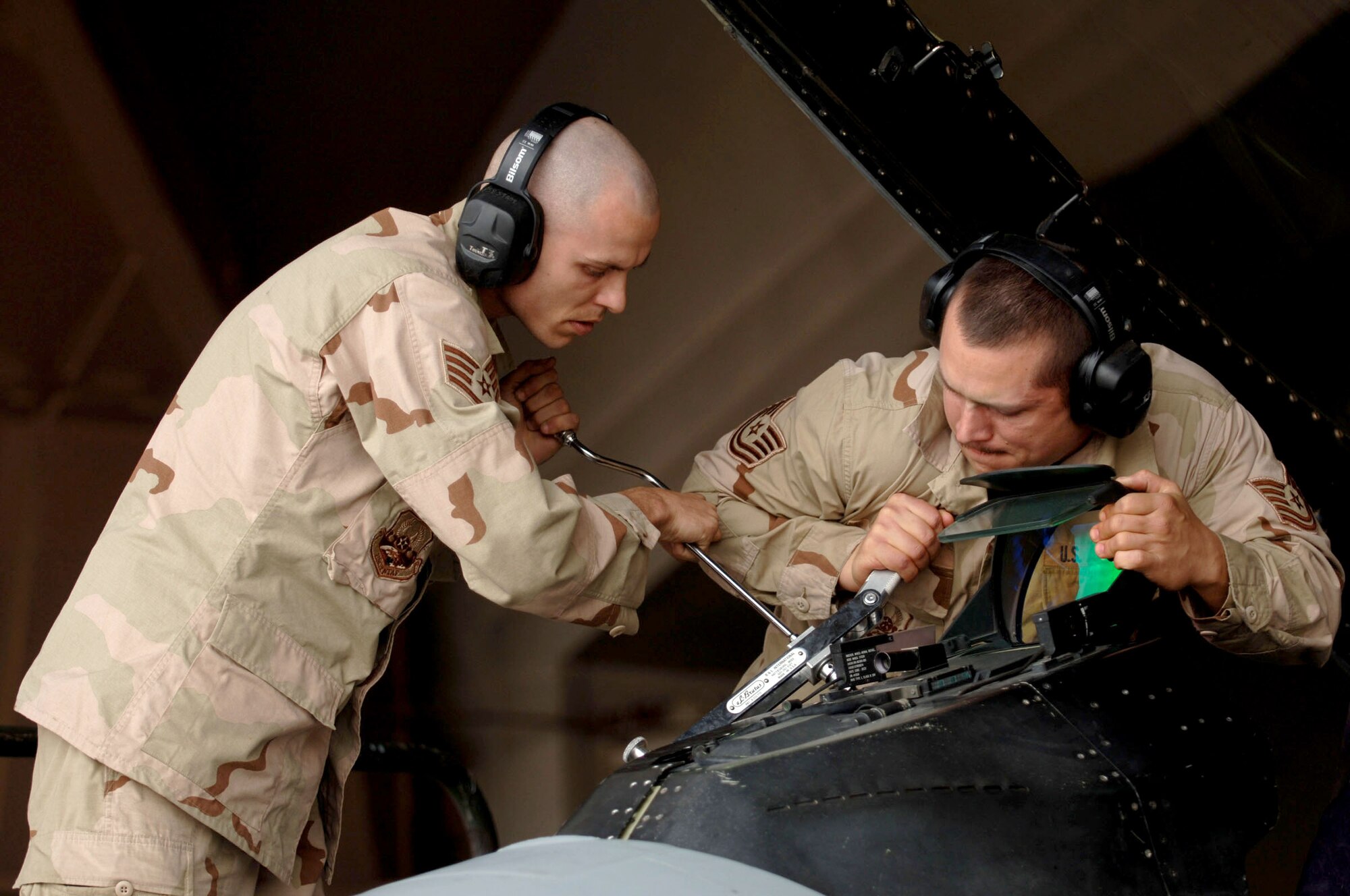 Staff Sgt. Adrian Abram, left, and Tech. Sgt. Travis Topel, 332nd Expeditionary Aircraft Maintenance Squadron, change the cockpit light assembly on an F-16 at Balad Air Base, Iraq. Sergeants Abram and Topel are both deployed from Aviano Air Base, Italy in support of Operation Iraqi Freedom. (Photo by Staff Sgt. Michael Holzworth)