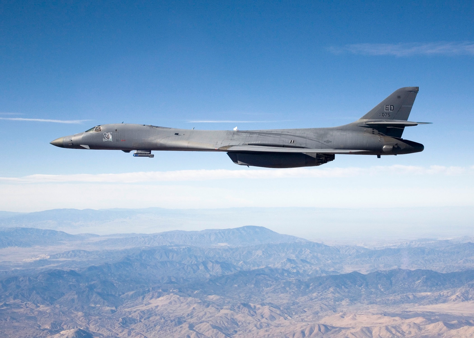 A B-1B Lancer carries the Sniper pod on its belly as it flies over Edwards' skies during a flight test here. The 419th Flight Test Squadron testers recently concluded the initial development of the Sniper pod installed on a B-1B here recently. The Sniper pod is an advanced targeting pod with a multi-sensor system that increases the aircraft's self-targeting capability. (Photo by Steve Zapka)