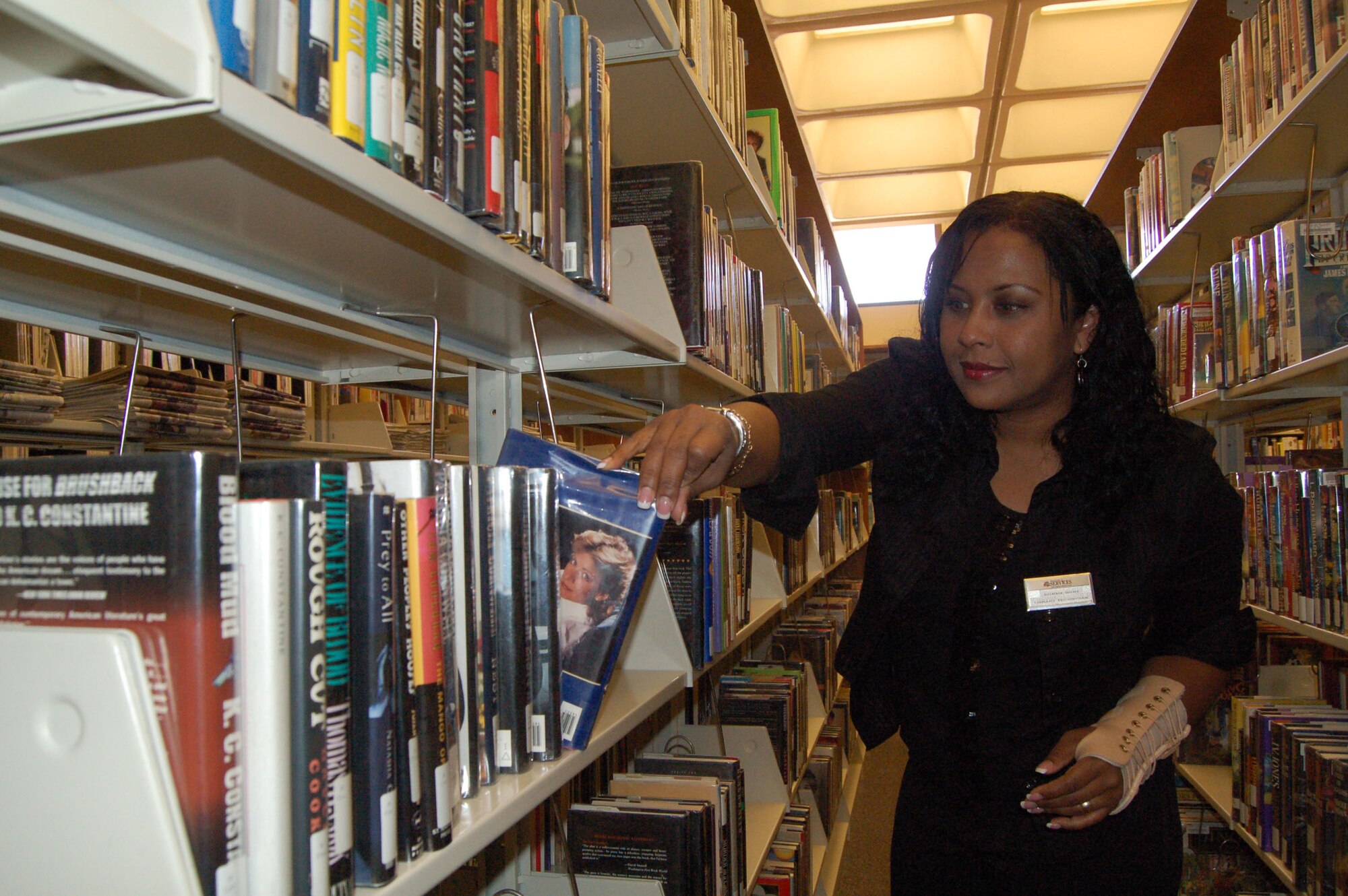 Peronica Hunt, Edwards Library technician, organizes books on a shelf. The Edwards Main Library achieved a five-star rating from the Air Force recently for the third consecutive time. The library was also the best in Air Force Materiel Command for fourth year in a row. (Photo by Airman 1st Class Julius Delos Reyes)