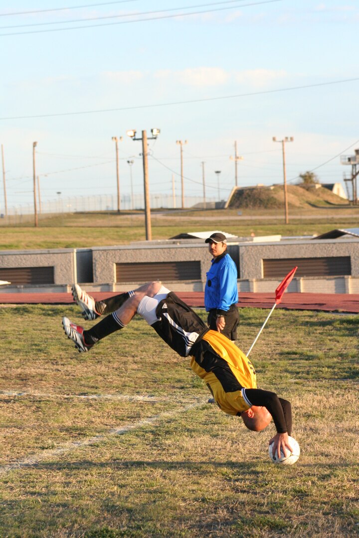 Zakary Fowkes from Hurlburt Field, Fla., somersaults before he inbounds against Davis-Monthan Air Force Base, Ariz./McChord AFB, Wash, Feb. 18 at the fifth Alamo City Military Open Soccer Tournament for the Defender's Cup on Lackland Air Force Base, Texas. (USAF photo by Army Spc. Tim Luukkonen)