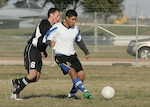 John Cardenas, right, from the Lackland Varsity Soccer Team, works to keep possession against a defender from Schriever Air Force Base, Colo., Feb. 16 during the early rounds of the fifth Alamo City Military Open Soccer Tournament for the Defender's Cup on Lackland Air Force Base, Texas. (USAF photo by Robbin Cresswell)
