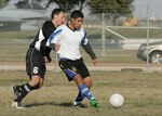 John Cardenas, right, from the Lackland Varsity Soccer Team, works to keep possession against a defender from Schriever Air Force Base, Colo., Feb. 16 during the early rounds of the fifth Alamo City Military Open Soccer Tournament for the Defender's Cup on Lackland Air Force Base, Texas. (USAF photo by Robbin Cresswell)