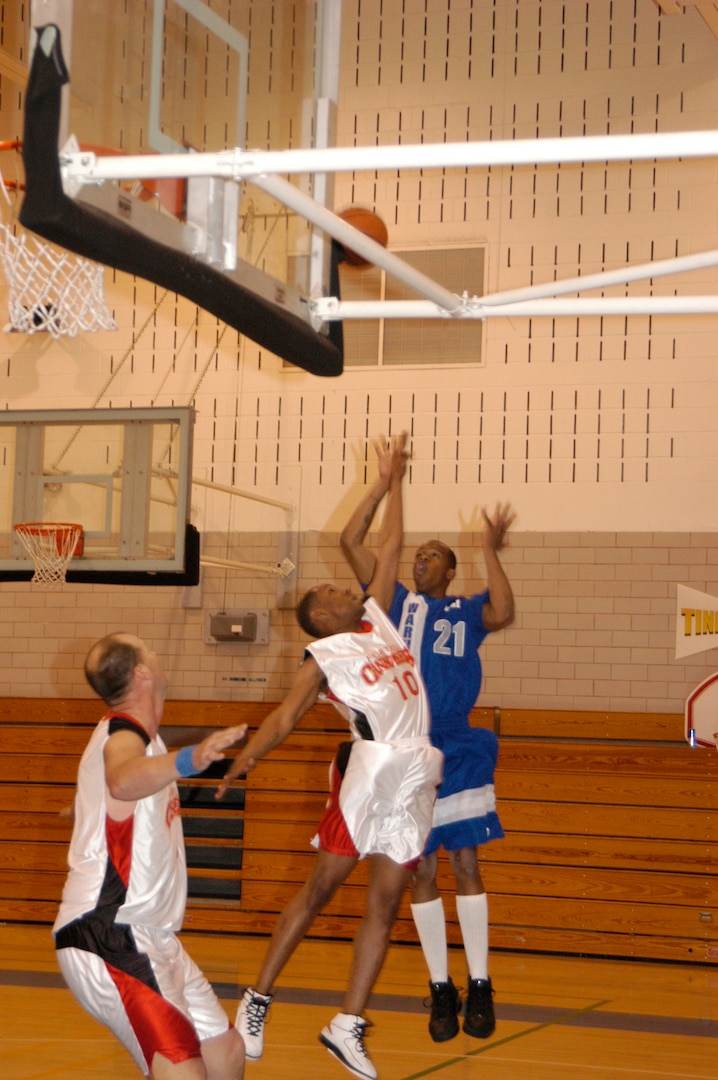 Fort Sill, Okla., Cannoneer Michael Smith attempt to block Warhawks' Paul Parkers shot during the final championship game of the Southwest Military Basketball League championship Feb. 18 at Brooks City-Base, Texas. The men's varsity basketball team from Lackland Air Force Base, Texas, won against the Cannoneers, 87-69. (USAF photo by April Blumer)                                